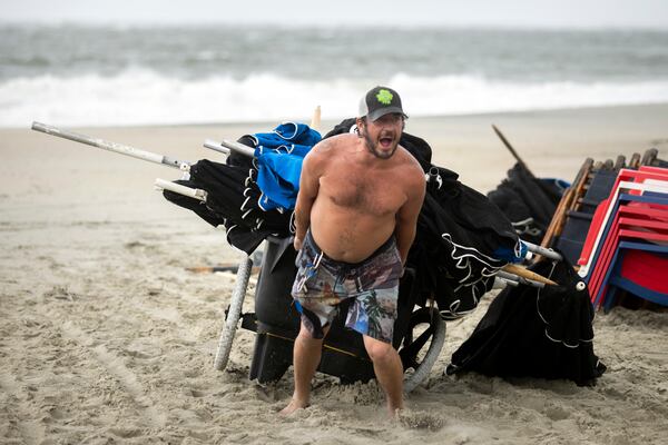 TYBEE ISLAND, GA - AUGUST 30, 2023: 
Gregory Drex Whiddon pulls a cart of umbrellas higher on the beach near the Tybee Island pier as the winds from Hurricane Idalia start to pick up, Wednesday, Aug. 30, 2023, in Tybee Island, Ga. Idalia came ashore in the lightly populated Big Bend region, where the Florida Panhandle curves into the peninsula. (AJC Photo/Stephen B. Morton)