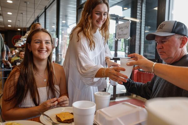 Avery Graus, (left) a senior at Marietta High School enjoys a meal at Red Eyed Mule with her sister Ashton, (center) and parents Mike (right) and Erica (not pictured) in Marietta on Thursday, May 23, 2024. Graus will be receiving free meals for life from the restaurant for having perfect attendance since kindergarten. (Natrice Miller/ AJC)