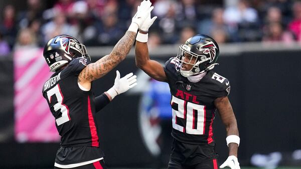 Atlanta Falcons safety Jessie Bates III, left, and cornerback Dee Alford, right, celebrate after a defensive play in the first half of an NFL football game against the Houston Texans in Atlanta, Sunday, Oct. 8, 2023. Bates, who signed a four-year, $64 million contract in free agency, is having a strong season and has been a mentor to the defensive backs. (AP Photo/Mike Stewart)