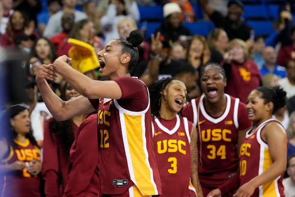 Southern California guard JuJu Watkins, left, celebrates with teammates during the second half of an NCAA college basketball game against UCLA Saturday, March 1, 2025, in Los Angeles. (AP Photo/Mark J. Terrill)