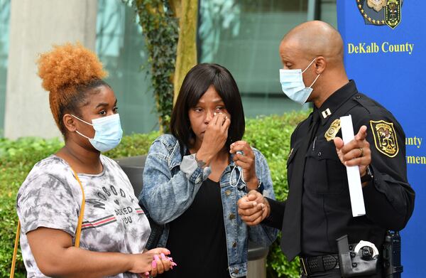 DeKalb County police Capt. T.R. Golden speaks with the boy’s sister, Rajjai Haszleton (left), and mother, Benji Abbey, after a news conference outside police headquarters Friday.