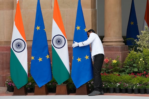 A worker adjusts a European Commission flag placed at the venue for the meeting between Indian Prime Minister Narendra Modi and European Commission President Ursula von der Leyen in New Delhi, India, Friday, Feb. 28, 2025. (AP Photo/Manish Swarup)