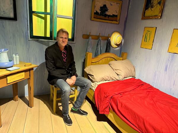 John Zaller, executive producer of the new Van Gogh Experience at the Exhibition Hub Art Center in Doravile, sits in a replica of Vincent Van Gogh's bedroom in Arles, France. RODNEY HO/ho@ajc.com