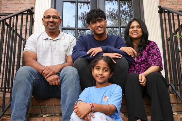 Sowmya Siragowni (right) poses for a portrait with her husband Rakesh Tekkam (left), her son Vaden,16, and daughter Anika, 8, in front of their home in Alpharetta on Wednesday, Oct. 25, 2023. Siragowni, a hospitalist at Emory Saint Joseph’s hospital, was diagnosed with stage 4 ovarian cancer five years ago. (Natrice Miller/ Natrice.miller@ajc.com)