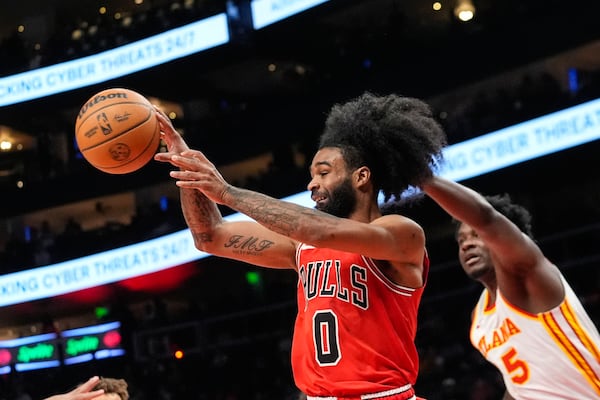 Chicago Bulls guard Coby White (0) passes the ball as Atlanta Hawks center Clint Capela (15) defends during the first half of an NBA basketball game Saturday, Nov. 9, 2024, in Atlanta. (AP Photo/ John Bazemore)