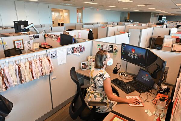 Carley Stephens, a community affairs manager at Gas South, logs in her computer in the company’s nearly empty headquarters in Atlanta. Shoppers are hitting stores and filling parking lots. Some diners are returning to sit-down restaurants. But many of metro Atlanta’s white-collar towers and office parks are still lonely places as employees continue to work remotely during the coronavirus pandemic. (Hyosub Shin / Hyosub.Shin@ajc.com)