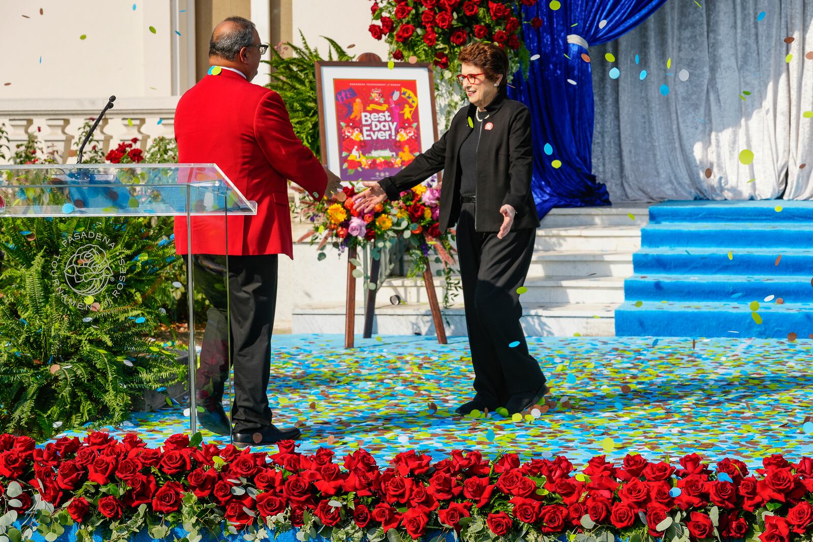 Tennis legend Billie Jean King is greeted by Tournament of Roses President Ed Morales at an event to introduce King as grand marshal of the 136th Rose Parade next year on the front steps of the Tournament House in Pasadena, Calif., Monday, Oct. 7, 2024. (AP Photo/Damian Dovarganes)