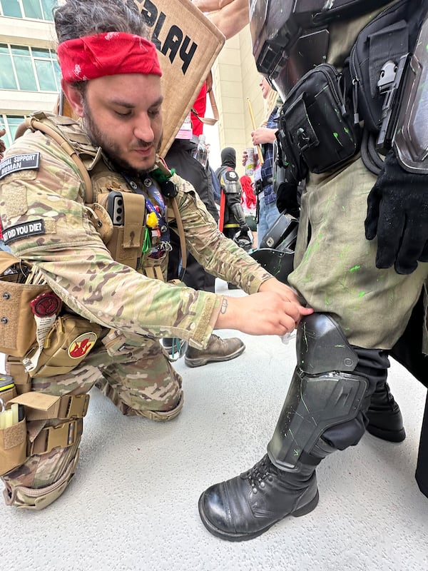 Russell Thorne, a mortgage loan officer from Nashville, is a volunteer Cosplay Medic who repairs torn, loose or broken outfits during Dragon Con. He glues a knee guard back into shape. RODNEY HO/rho@ajc.com