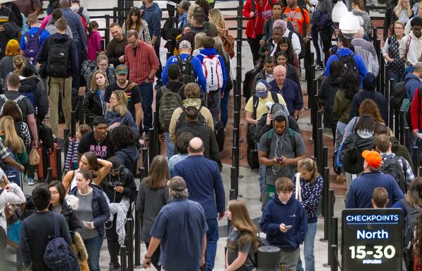 Travelers weave through a long line to get to the security checkpoint at Hartsfield-Jackson International Airport Sunday on what is expected to set a record travel day for the U.S. airline industry on December 1, 2019.  (Photo: STEVE SCHAEFER / SPECIAL TO THE AJC)