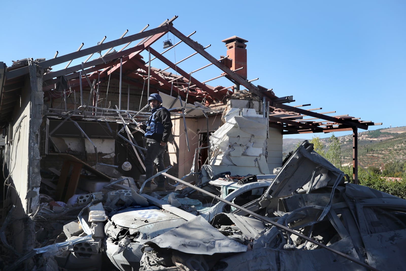 A journalist observes the site where an Israeli airstrike hit a compound housing journalists, killing three media staffers from two different news agencies according to Lebanon's state-run National News Agency, in Hasbaya village, southeast Lebanon, Friday, Oct. 25, 2024. (AP Photo/Mohammed Zaatari)