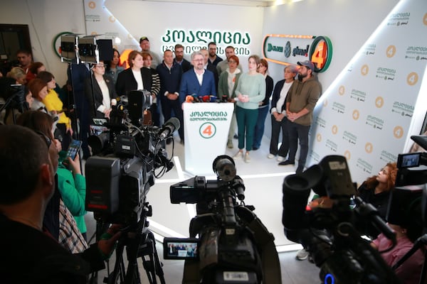 Nika Gvaramia, leader of Coalition for Changes, center, speaks to the media at coalition's headquarters after the parliamentary election in Tbilisi, Georgia, Sunday, Oct. 27, 2024. (AP Photo/Zurab Tsertsvadze)