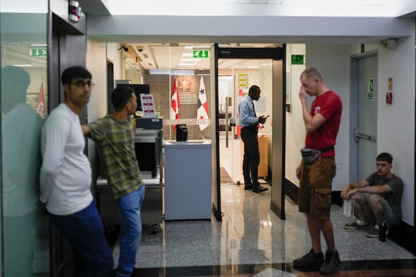 Migrants from Afghanistan and Russia, who were deported from the U.S., wait at the Canadian Embassy in Panama City, Tuesday, March 18, 2025, in an effort to seek asylum. (AP Photo/Matias Delacroix)