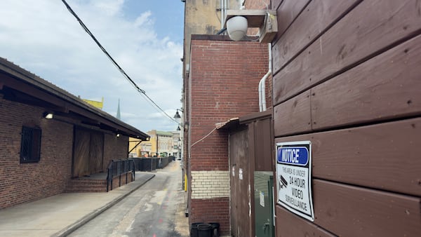 The alley in downtown Macon where Albert Kenneth Knight Jr. was beaten to death in the predawn hours of May 24. One of the video cameras that captured footage of the attack can be seen at the top of this photograph, mounted on a wall. (Joe Kovac Jr. / AJC)