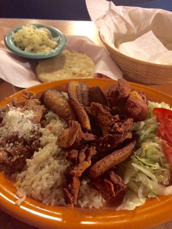 The Salvadoran fried chicken plate at Rincon Latino on Buford Highway is recommended. Behind it, and to the left: pupusa with chicharron and cheese. CONTRIBUTED BY WENDELL BROCK