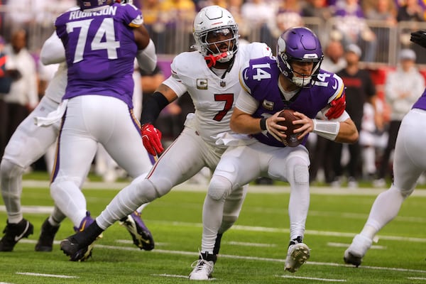 Minnesota Vikings quarterback Sam Darnold (14) is sacked by Arizona Cardinals linebacker Kyzir White (7) during the first half of an NFL football game Sunday, Dec. 1, 2024, in Minneapolis. (AP Photo/Bruce Kluckhohn)