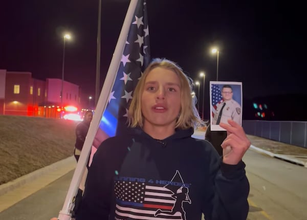 Andrew Collinson holds a photo of Eric Minix on Jan. 10. The Georgia teenager ran a mile in honor of the deputy who was killed in the line of duty Jan. 4.