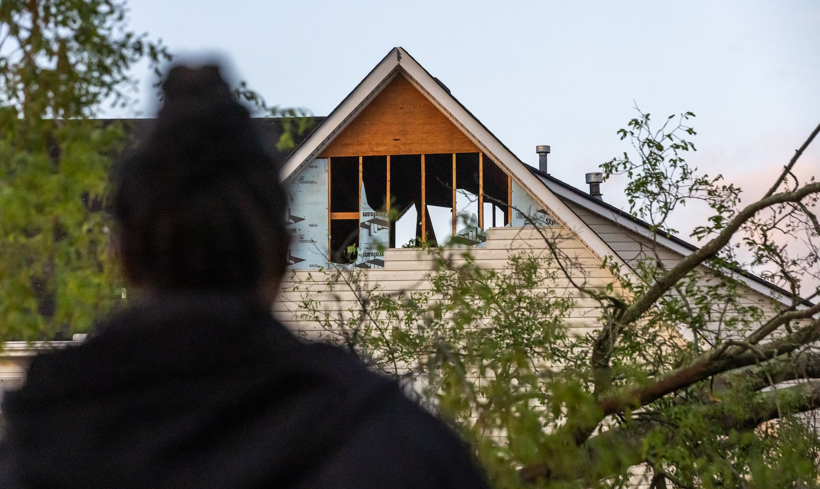 Tijuana Harris looks at the damage to her neighbor's home in Wolverton Court after a night of turbulent storms. Cleanup efforts were underway Wednesday, April 3, 2024, in Rockdale County, where at least one tornado was reported to have touched down. (John Spink / John.Spink@ajc.com)