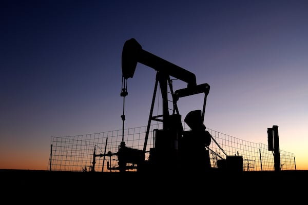 A pumpjack operates at dawn in a pasture, Monday, Sept. 30, 2024, near Hays, Kan. (AP Photo/Charlie Riedel)