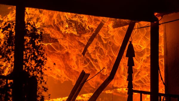 A house burns during the Woolsey Fire on November 9, 2018 in Malibu, California. After a experiencing a mass shooting, residents of Thousand Oaks are threatened by the ignition of two nearby dangerous wildfires, including the Woolsey Fire which has reached the Pacific Coast at Malibu.