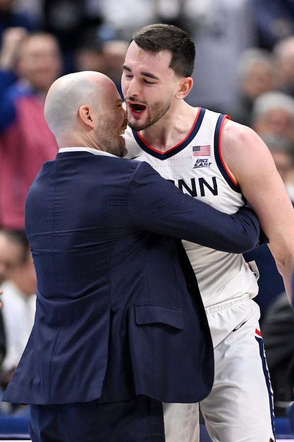 UConn forward Alex Karaban, right, is embraces by assistant coach Luke Murray at the end of an NCAA basketball game against Marquette, Wednesday, March 5, 2025, in Storrs, Conn. (AP Photo/Jessica Hill)