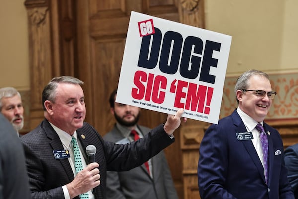 Sen. Frank Ginn, R-Danielsville, holds up a sign that reads DOGE Sic ‘em in the Senate chambers on Crossover Day at the Georgia State Capitol on Thursday, March 6, 2025. (Natrice Miller/ AJC)