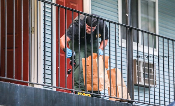 An investigator collects evidence on the second floor of the Efficiency Lodge outside Douglasville on Tuesday morning.