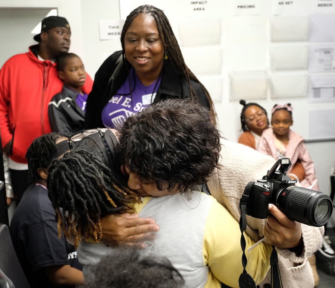 Cynthia Risper-Jett is hugged by Cherene Williams as Dedra Evans looks on after learning that they have a gift card to spend at Academy. Carson Beck was on site at an Athens Academy store Sunday December 17, 2023, to give out gift cards to lucky members of area Boys and Girls Clubs. Academy contributed $200 for each child and he kicked in $135 more of his own money to help families out. 
credit: Nell Carroll for the AJC