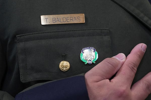 Border Patrol Agent Trinidad Balderas looks at his new chaplain pin after graduating from the program, Thursday, Nov. 21, 2024, in Dania Beach, Fla. (AP Photo/Marta Lavandier)