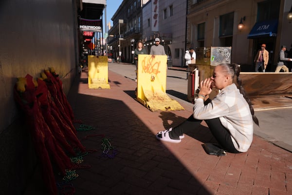 Samantha Petry, who works in the area, visits a flower memorial set up on Canal and Bourbon Street, Thursday, Jan. 2, 2025 in New Orleans. (AP Photo/George Walker IV)