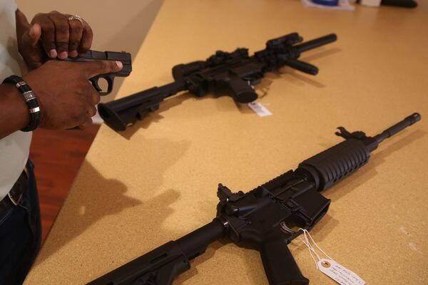 Mark Major, a firearms dealer in Lithonia, conducts a safety check on a handgun. Major, a self-described independent who typically votes Republican, says Abrams  positions on gun control are among the factors that have led to his support of Brian Kemp. (Max Blau / For The Atlanta Journal-Constitution)