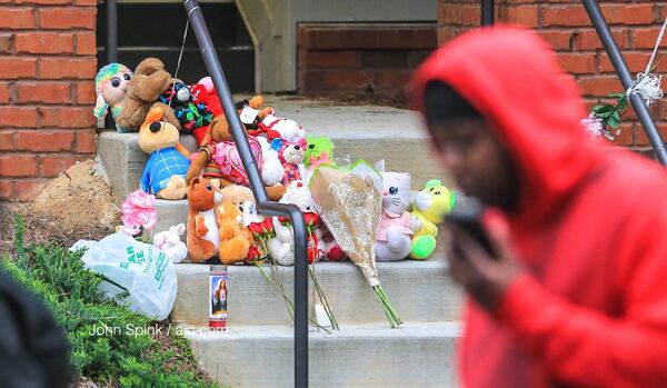 There was a growing memorial Monday in front of an apartment where a 14-year-old girl and a man were killed Sunday morning. JOHN SPINK / JSPINK@AJC.COM