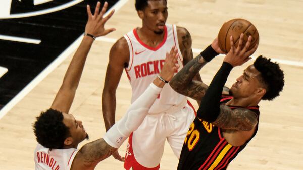 Houston Rockets forward Cameron Reynolds (left) tries to block Hawks forward John Collins (20) during the first half Sunday, May 16, 2021, at State Farm Arena in Atlanta. The Hawks won the regular season finale 124-95. (Ben Gray/AP)