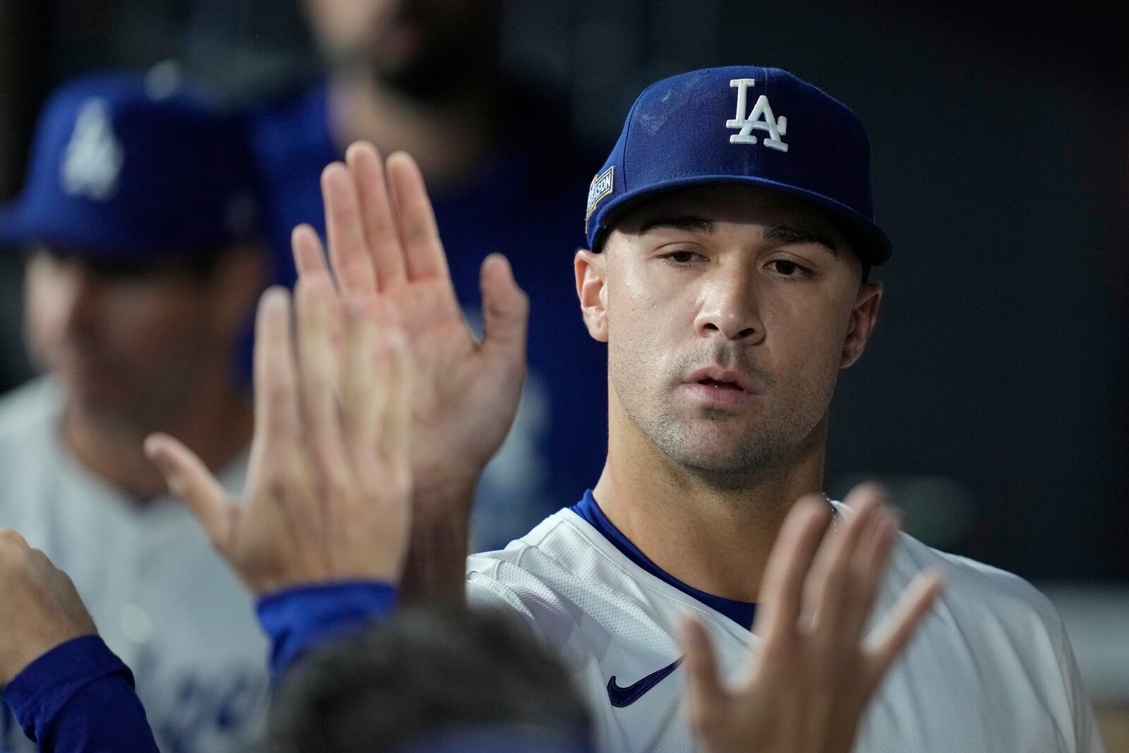 Los Angeles Dodgers starting pitcher Jack Flaherty is high-fived in the dugout after being relieved during the sixth inning in Game 2 of a baseball NL Division Series against the San Diego Padres, Sunday, Oct. 6, 2024, in Los Angeles. (AP Photo/Ashley Landis)