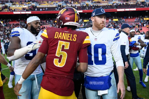 Washington Commanders quarterback Jayden Daniels (5) Dallas Cowboys quarterback Cooper Rush (10) shake hands after an NFL football game, Sunday, Nov. 24, 2024, in Landover, Md. The Cowboys on 34-26. (AP Photo/Nick Wass)