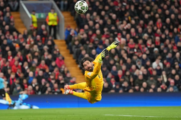 Liverpool's goalkeeper Alisson dives for the ball during the Champions League round of 16 second leg soccer match between Liverpool and Paris Saint-Germain at Anfield in Liverpool, England, Tuesday, March 11, 2025. (AP Photo/Jon Super)