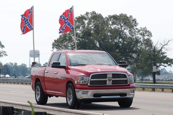 A truck flying Confederate flags passes by the Talladega Superspeedway prior to the NASCAR Cup Series auto race at the in Talladega Ala., Sunday June 21, 2020 (AP Photo/John Bazemore)