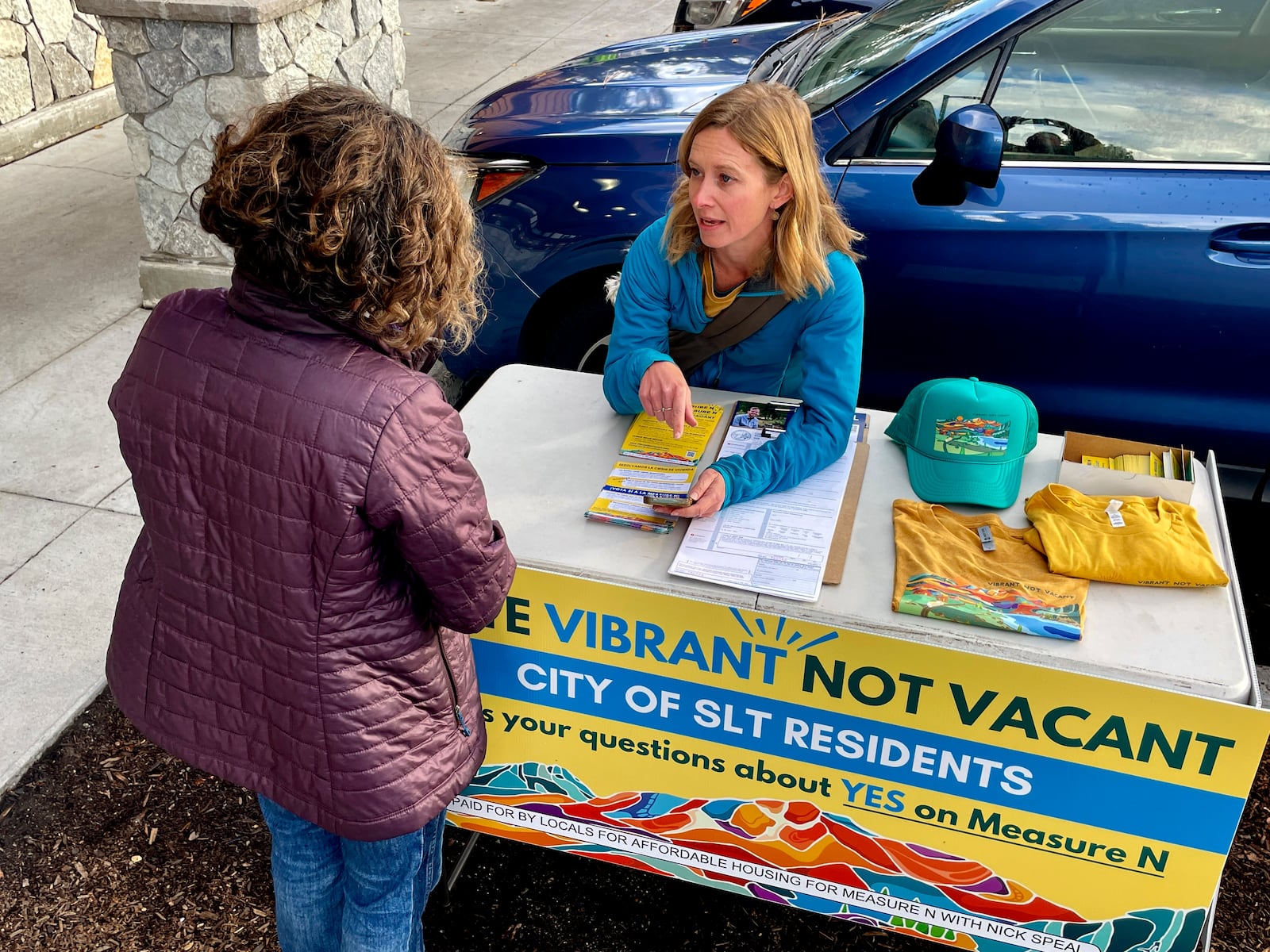 Amelia Richmond, Co-Founder, Locals for Affordable Housing, talks to a voter outside a grocery store in South Lake Tahoe, Calif. on Thursday, Oct. 17, 2024, where voters will decide whether to approve Measure N, which will mandate a tax to homeowners who leave their homes vacant for more than half the year.v(AP Photo/Haven Daley)