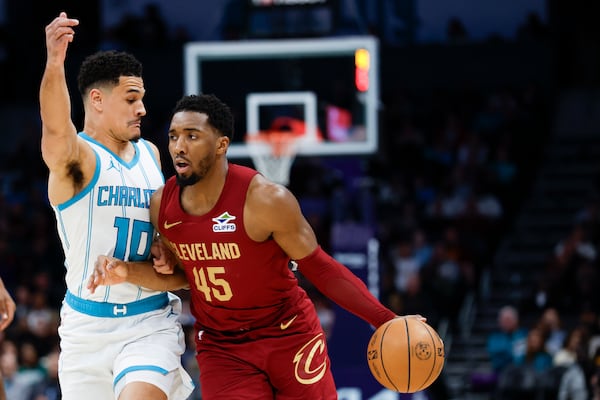 Cleveland Cavaliers guard Donovan Mitchell (45) drives into Charlotte Hornets guard Josh Green, left, during the first half of an NBA basketball game in Charlotte, N.C., Friday, March 7, 2025. (AP Photo/Nell Redmond)