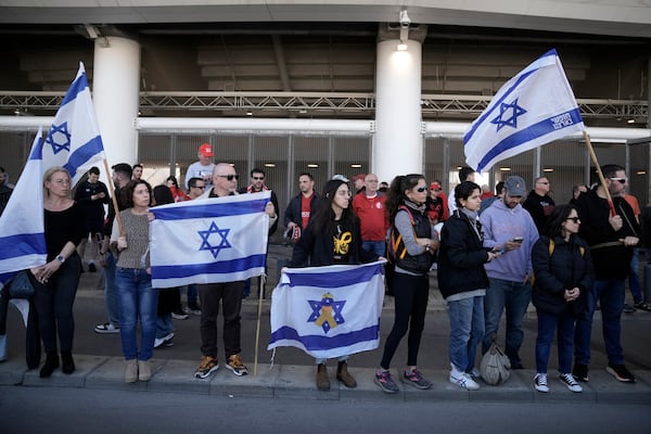 Friends, family and soccer fans at a public memorial ceremony for slain hostage Tsachi Idan, a fan of Hapoel Tel Aviv F.C., who was killed in Hamas captivity in the Gaza Strip, watch a van carrying his coffin outside of Bloomfield Stadium in Tel Aviv, Israel, Friday, Feb. 28, 2025. (AP Photo/Leo Correa)