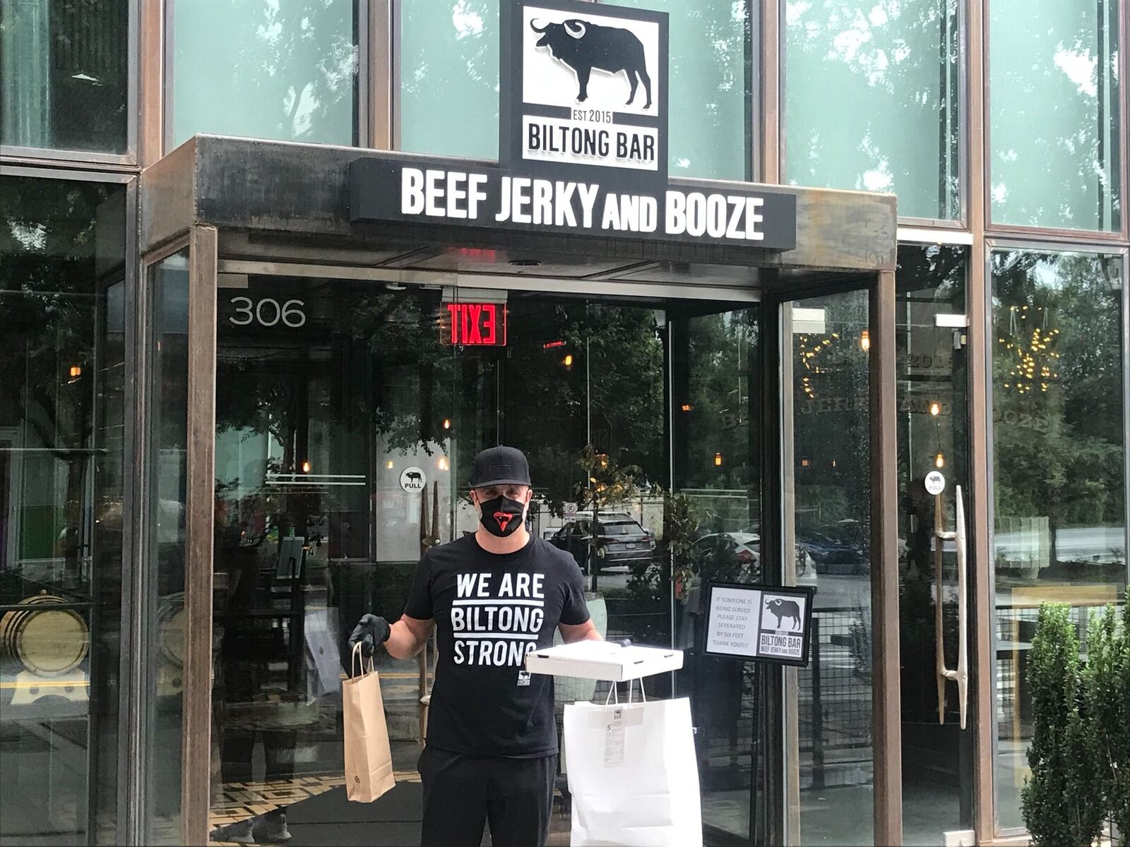 Restaurateur Justin Anthony holds a takeout order. Working out of the kitchen at Biltong Bar in Buckhead, he is offering a takeout menu of favorites from his South African dining concepts 10 Degrees South, Biltong Bar and Yebo Beach Haus. LIGAYA FIGUERAS/LIGAYA.FIGUERAS@AJC.COM