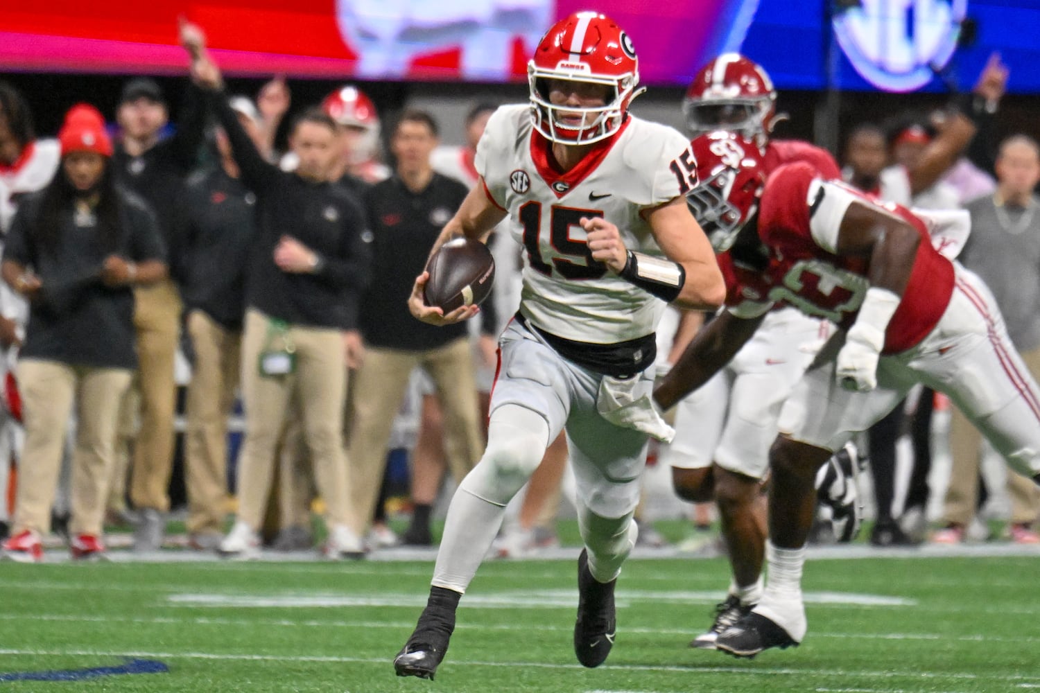 Georgia Bulldogs quarterback Carson Beck (15) scrambles for yardage against the Alabama Crimson Tide during the first half of the SEC Championship football game at the Mercedes-Benz Stadium in Atlanta, on Saturday, December 2, 2023. (Hyosub Shin / Hyosub.Shin@ajc.com)