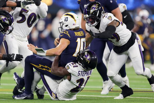 Baltimore Ravens cornerback Brandon Stephens (21) sacks Los Angeles Chargers quarterback Justin Herbert (10) during the second half of an NFL football game Monday, Nov. 25, 2024, in Inglewood, Calif. (AP Photo/Ryan Sun)