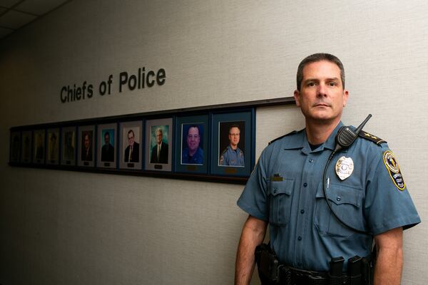 New Gwinnett County police Chief Tom Doran poses with portraits of previous chiefs at the Gwinnett County police headquarters in Lawrenceville. Outgoing Chief of Police Butch Ayers retired Nov. 15, after five years in charge and more than three decades with the department. (Photo/Rebecca Wright for the Atlanta Journal-Constitution)