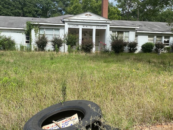 Eight years ago, Stewart Webster Hospital, in a financial tailspin, closed its doors for the last time. Now weeds and trash litter the grounds around the facility. (Andy Miller / Georgia Health News)