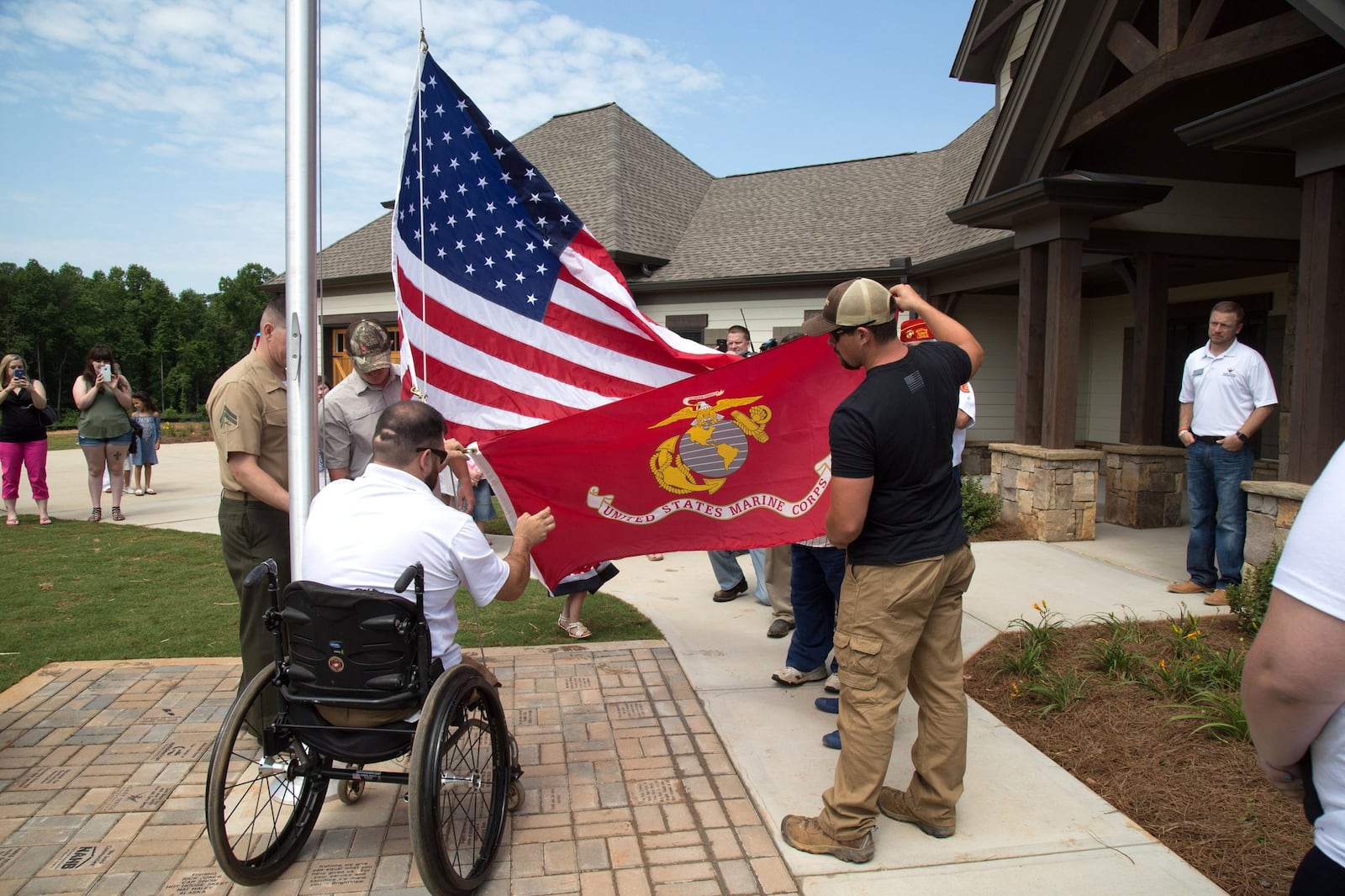 Retired Cpl. Sean Adams prepares to raise the American and Marine Corps flags for the first time at his new home in Maysville on May 19, 2017. Nationwide, the Gary Sinise Foundation’s R.I.S.E. program (Restoring Independence Supporting Empowerment) honors America’s severely wounded defenders, veterans, first responders and their families by building them specially adapted smart homes. STEVE SCHAEFER / SPECIAL TO THE AJC