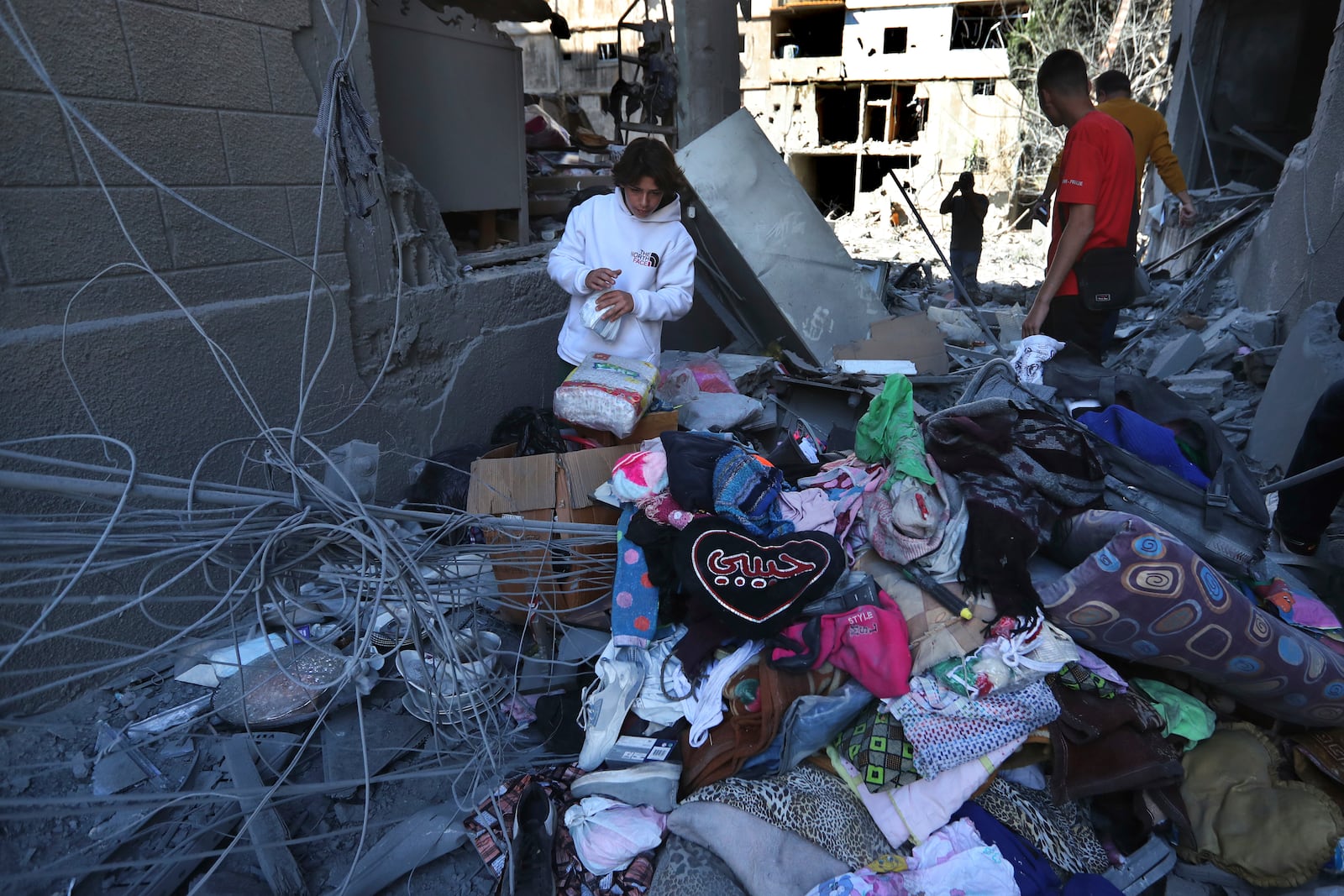 Lebanese citizens collect their belongings from their destroyed apartments that were hit by Israeli airstrikes, in Tyre, south Lebanon, Thursday, Oct. 24, 2024. (AP Photo/Mohammed Zaatari)