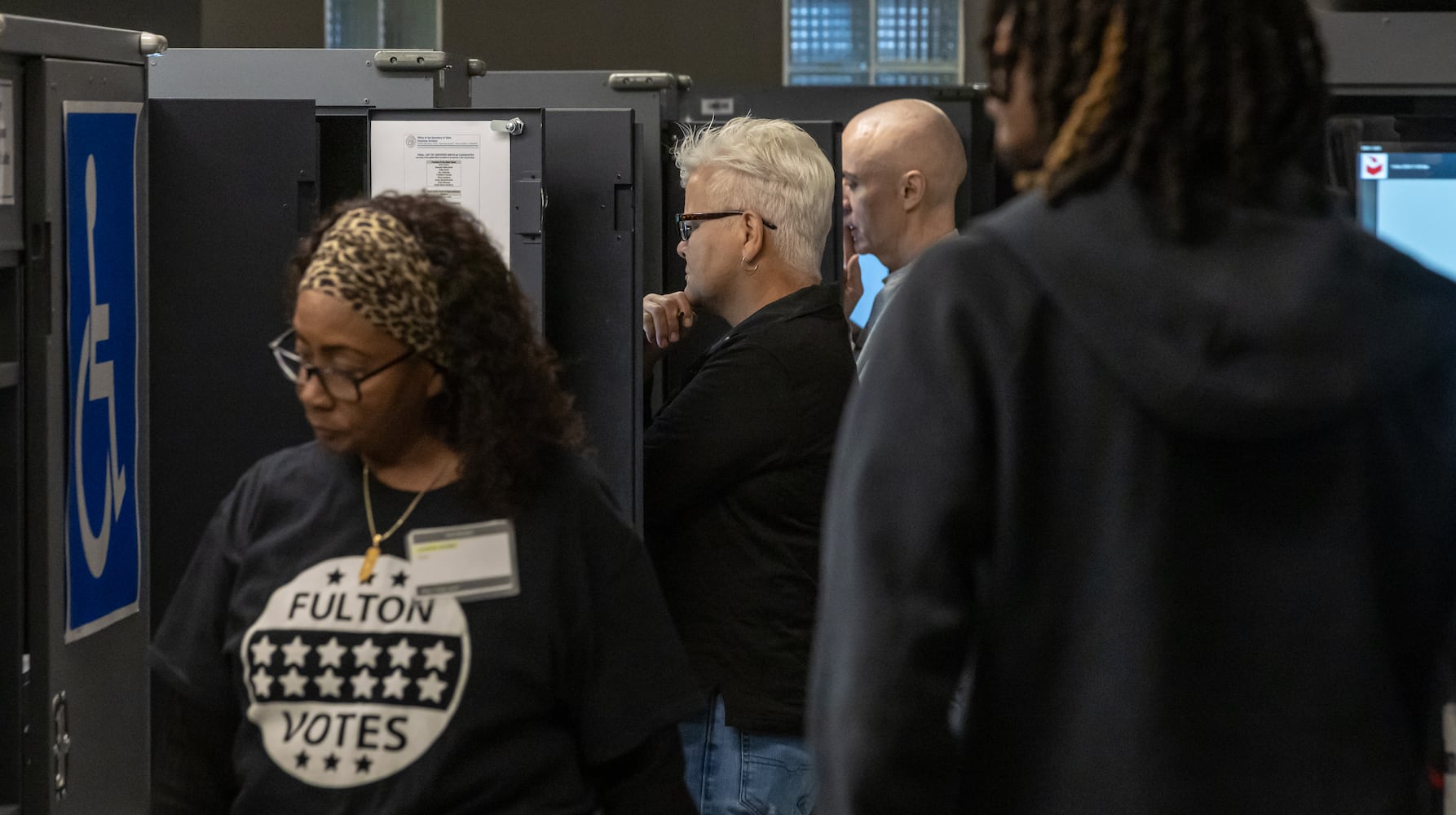 Michelle Kiepper (center) contemplates her vote as poll worker Gloria Cooper (left) waits to take ballots at the Joan P. Garner Library located at 980 Ponce De Leon Ave N in Atlanta on Tuesday, Oct. 15, 2024. Polling places opened for the first day of early voting Tuesday as Georgia prepares for another tour as one of America’s most hotly contested states. The state’s 8.2 million registered voters will consider important races up and down the ballot. (John Spink/AJC)