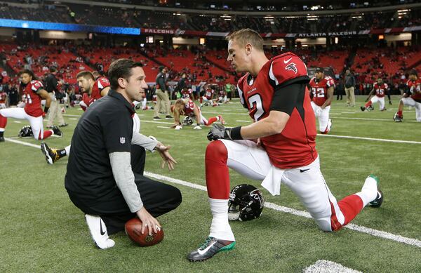 Falcons offensive coordinator Kyle Shanahan (left) speaks with quarterback Matt Ryan before a game against the Kansas City Chiefs, Sunday, Dec. 4, 2016, in Atlanta. (AP Photo/John Bazemore)