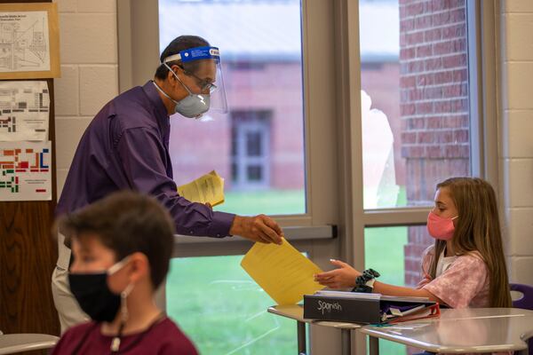 Cartersville Middle School Spanish teacher Omar Nuez wears a face mask and a face shield while interacting with students in his classroom at Cartersville Middle School in Cartersville in this Thursday, August 20, 2020 file photo.  (ALYSSA POINTER / ALYSSA.POINTER@AJC.COM)