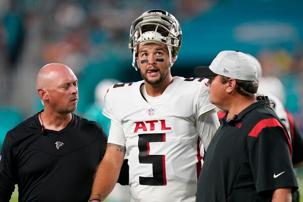 Atlanta Falcons quarterback AJ McCarron (5) is assisted off the field after he was injured on a play, during the first half of a preseason NFL football game against the Miami Dolphins, Saturday, Aug. 21, 2021, in Miami Gardens, Fla. (AP Photo/Lynne Sladky)